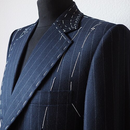 A bespoke navy pinstripe suit on a tailor's form