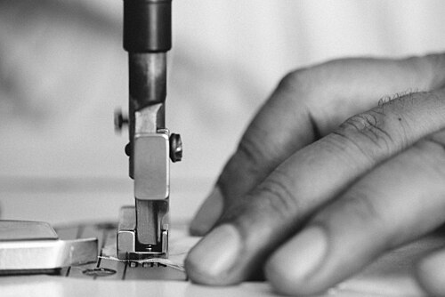 Close-up of sewing machine needle guiding fabric